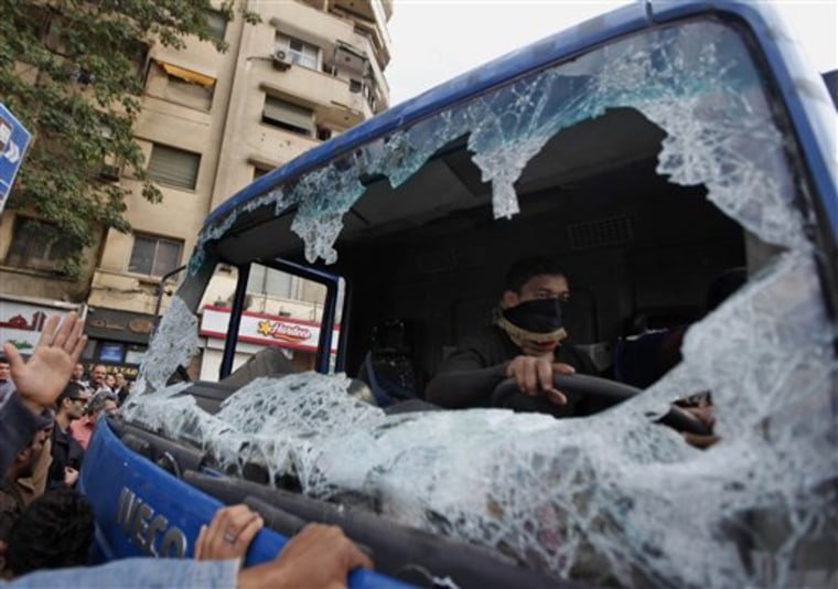 A protester sits in a police truck destroyed during clashes in Tahrir Square in Cairo, Egypt, Saturday, Nov. 19, 2011. Thousands of police clashed with protesters for control of downtown Cairo's Tahrir Square on Saturday after security forces tried to stop activists from staging a long-term sit-in there. The violence took place just nine days before Egypt's first elections since the ouster of longtime President Hosni Mubarak in February. (AP Photo/Khalil Hamra)